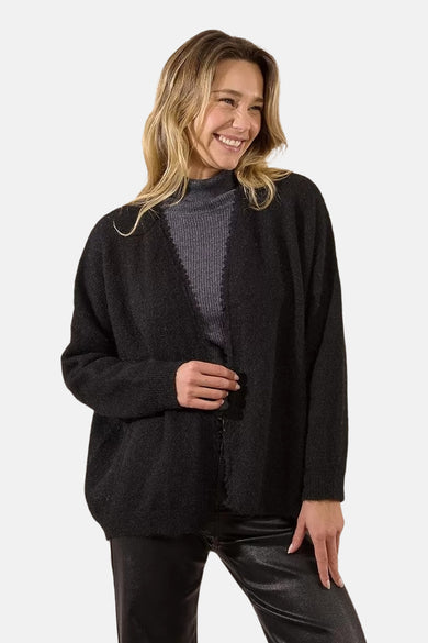 Zwarte gilet van Molly Bracken, gedragen over een grijze coltrui en een zwarte leren broek.