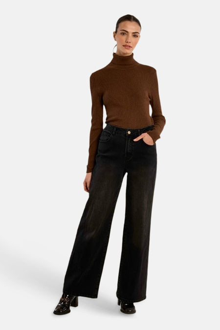 Femme portant un pull col montant brun Molly Bracken et un pantalon noir.