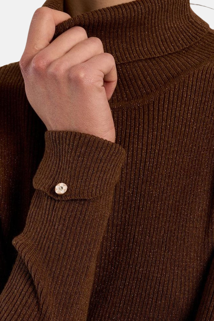 Zoom sur le col montant et la manche boutonnée d’un pull brun côtelé Molly Bracken.