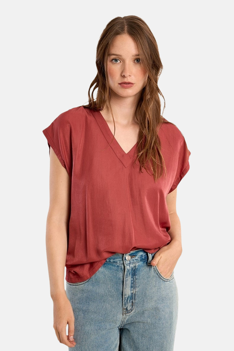 Rode blouse met korte mouwen van Molly Bracken, gedragen met een lichtblauwe jeans met hoge taille.