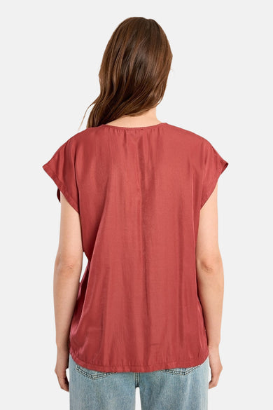 Rode blouse met korte mouwen van Molly Bracken, van achteren gezien, gedragen met een lichte spijkerbroek.