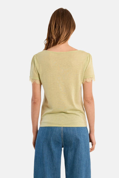 T-shirt vert de Molly Bracken, manches courtes avec dentelle, porté avec un pantalon bleu taille haute, vue de dos.
