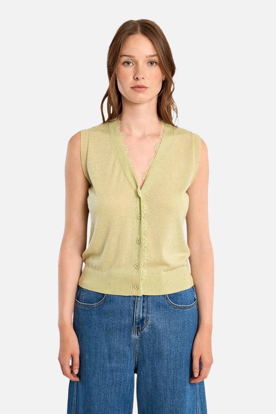 Groene gilet van Molly Bracken, met een bewerkte kraag en gedragen met een wijde blauwe broek.