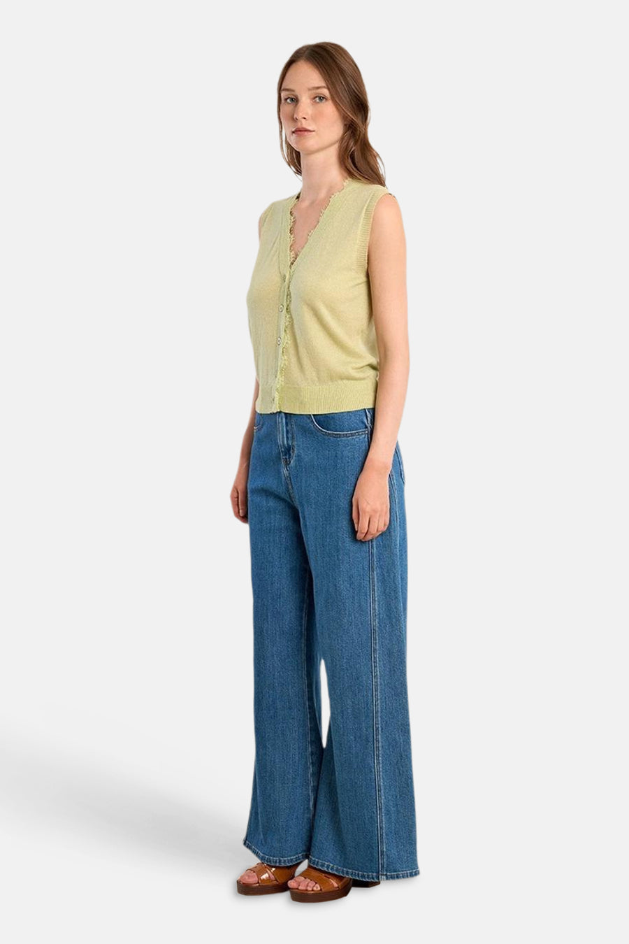 Groen gilet van Molly Bracken met borduurwerk en kant, gedragen met een high-waisted jeans en bruine sandalen.
