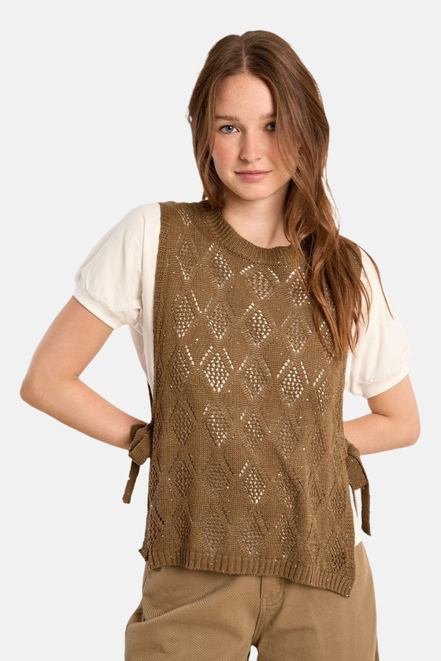 Pull ras du cou cognac de Molly Bracken, motif losanges ajourés, liens à nouer sur les côtés porté sur un t-shirt blanc.