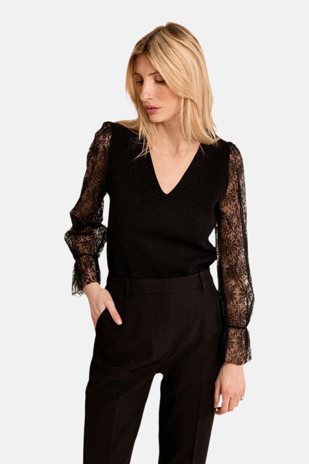 Black V-neck sweater with lace sleeves by Molly Bracken, worn with black trousers, side view