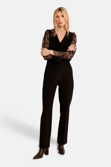 Black round-neck sweater with lace sleeves by Molly Bracken, worn with high-waisted trousers and ankle boots, full-length front view