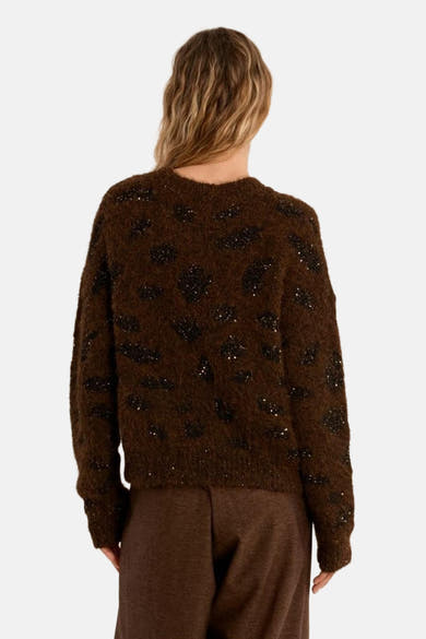 Brown O-neck sweater with black sequin spots, back view, fuzzy texture, long sleeves, worn with brown trousers