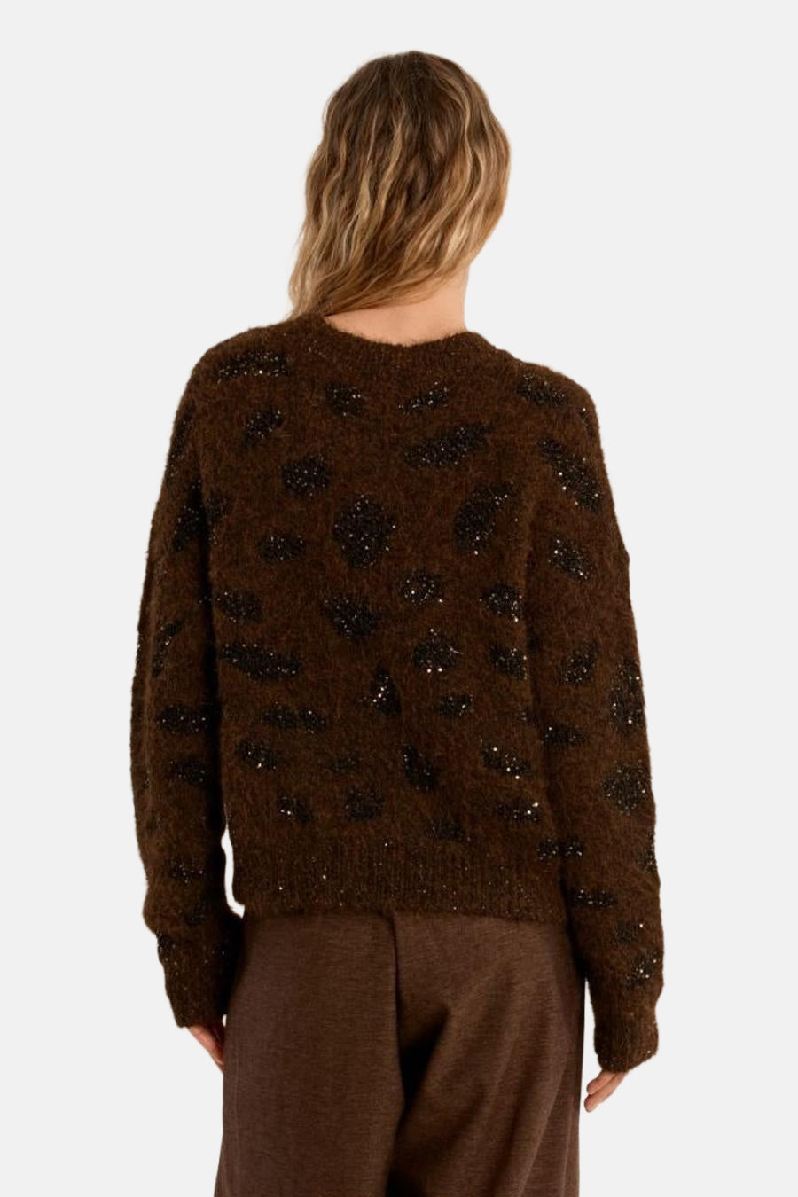 Brown O-neck sweater with black sequin spots, back view, fuzzy texture, long sleeves, worn with brown trousers