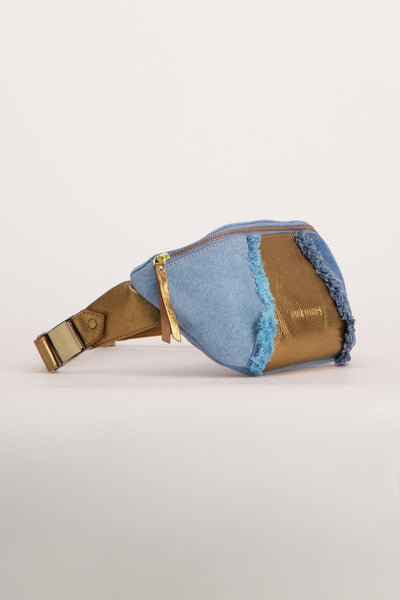 Sac bandoulière en jean bleu de PAUL MARIUS, avec empiècements en cuir doré et franges décoratives.
