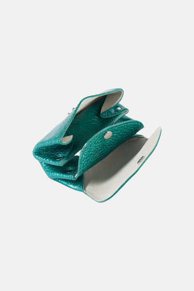 Sac à main vert sarcelle en cuir texturé de PAUL MARIUS, ouvert, avec des compartiments et des boutons-pression argentés.