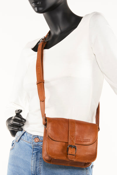 Sac à bandoulière brun de PAUL MARIUS, porté par un mannequin avec un jean bleu et un pull blanc.