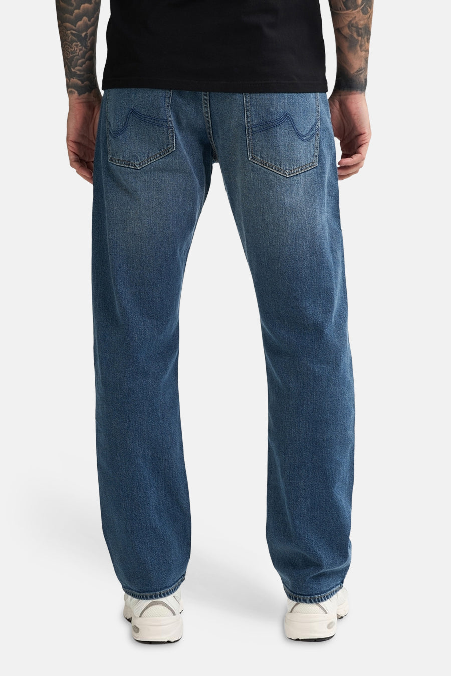 Mid blue denim jeans by LEWIS, back view, relaxed fit with classic stitching and white sneakers.
