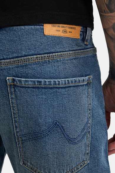 Mid blue denim jeans by Lewis, back view with tan leather waistband label and contrast stitching on rear pocket
