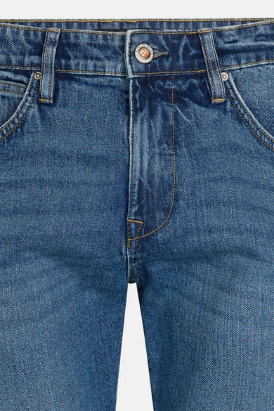 Mid blue denim jeans by LEWIS, front close-up with faded wash, brown stitching, and button fly detail