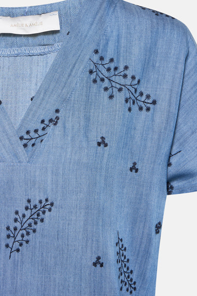 Blouse à manches courtes bleu denim d'AMELIE ET AMELIE avec broderies florales bleu marine.