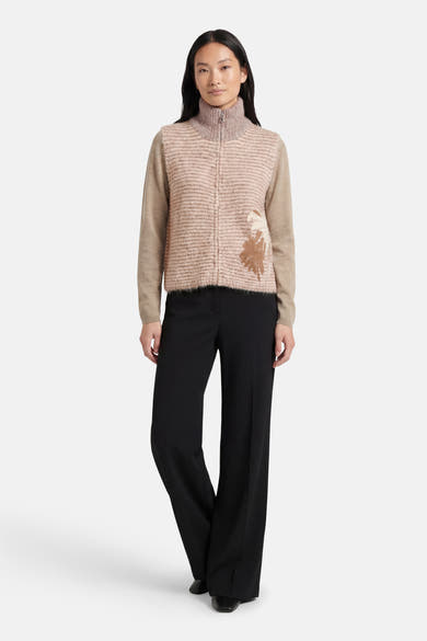 Beige ADORE cardigan met horizontale strepen, met aangebracht bloemenpatroon en wijde zwarte broek.