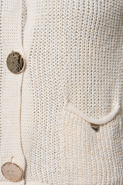 Beige vest van opengewerkt breiwerk van AMELIE ET AMELIE, met getextureerde gouden knopen en een klein decoratief zakje.