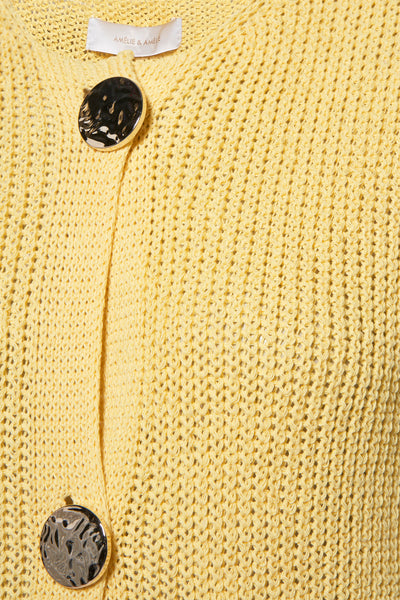 Gilet jaune in maille, door AMELIE ET AMELIE, met twee decoratieve zilveren knoppen.