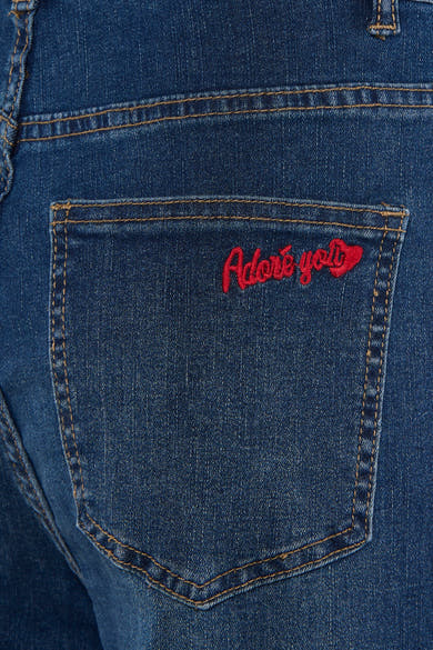 Jean large bleu moyen de ADORE, avec broderie rouge sur la poche arrière.
