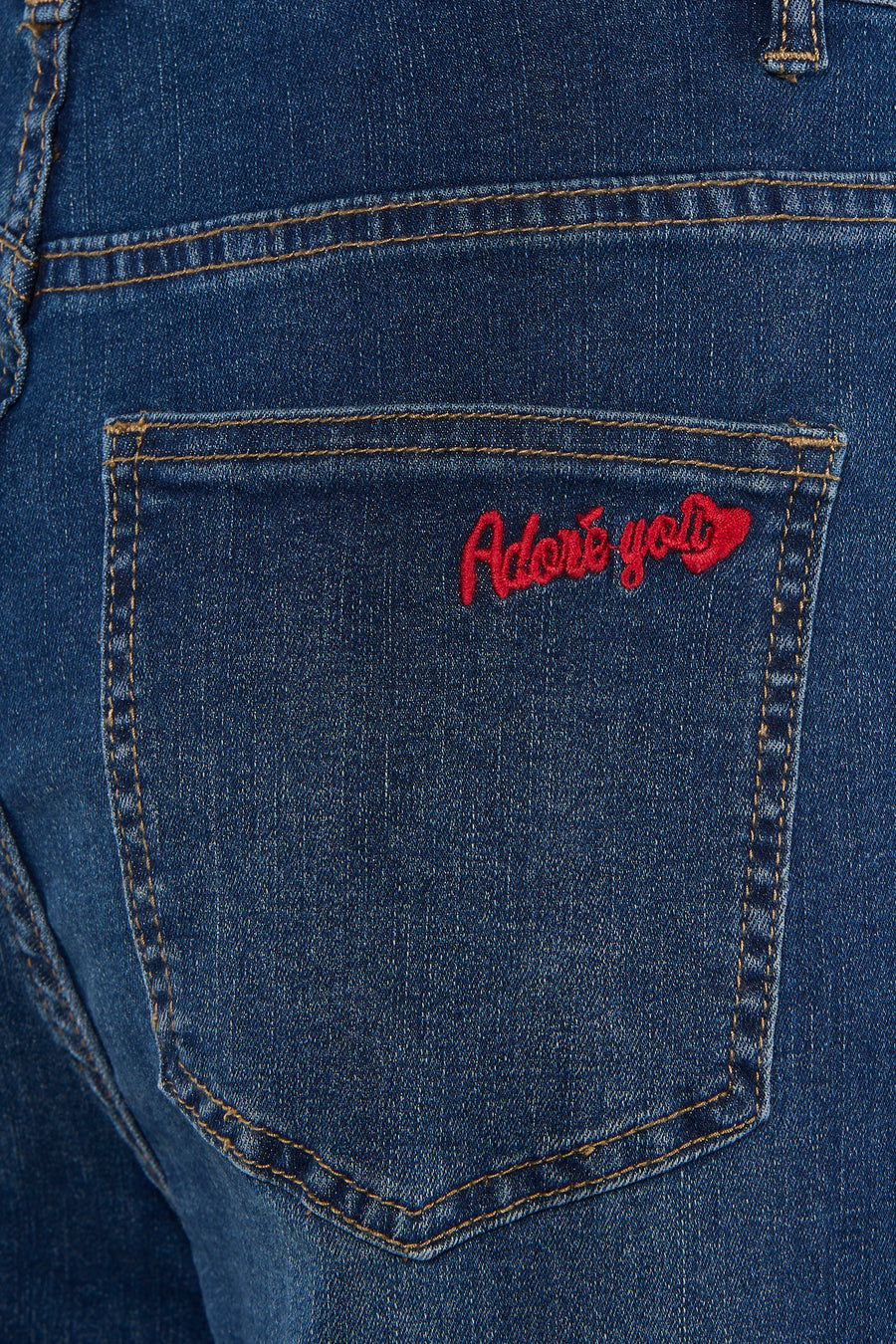 Jean large bleu moyen de ADORE, avec broderie rouge sur la poche arrière.
