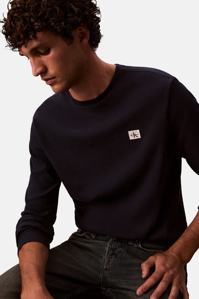 Marineblauw T-shirt met lange mouwen in wafelbreisel van Calvin Klein, gedragen met een spijkerbroek