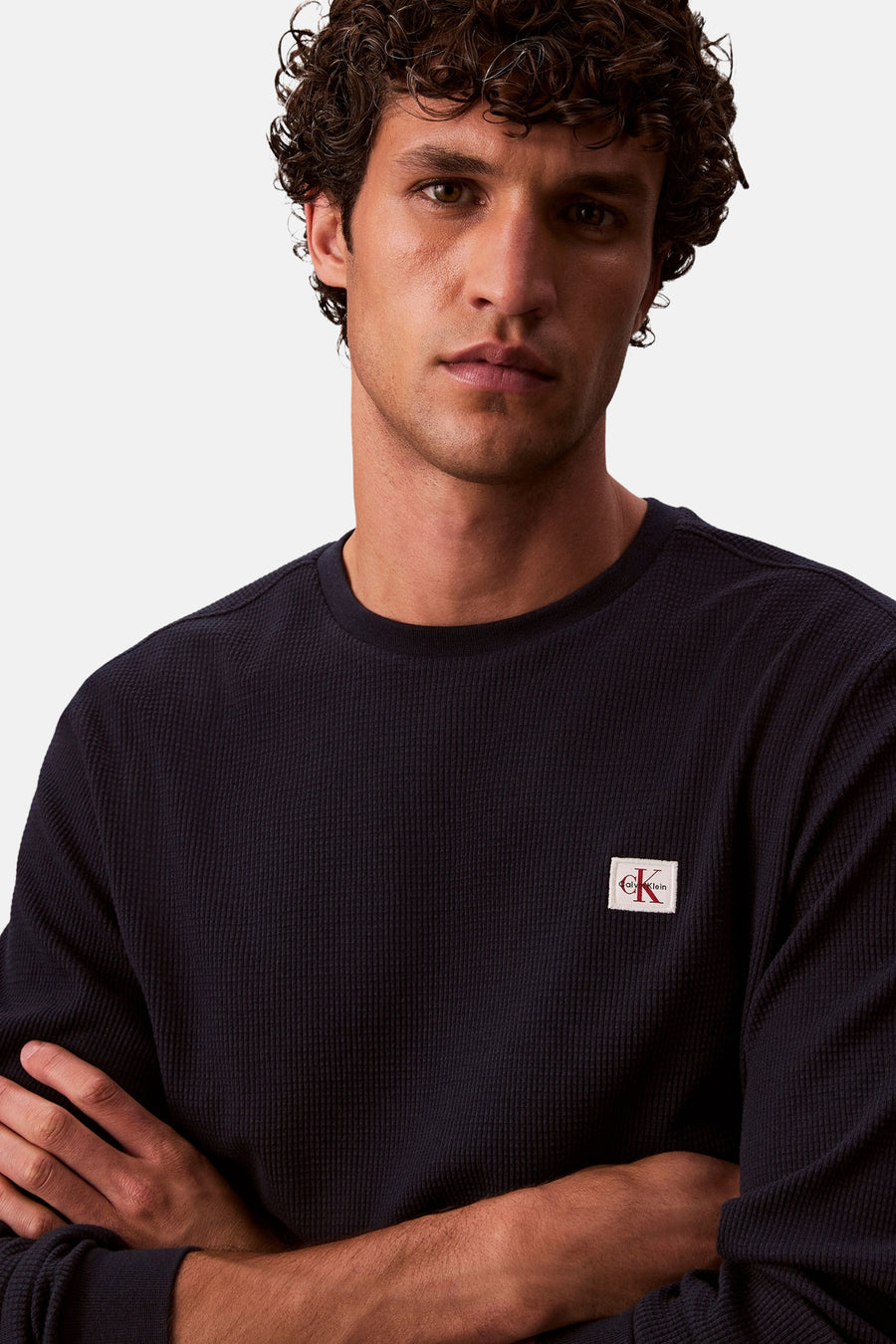 Marineblauwe T-shirt met lange mouwen van Calvin Klein, in wafelbreisel met vierkant logo op de borst.