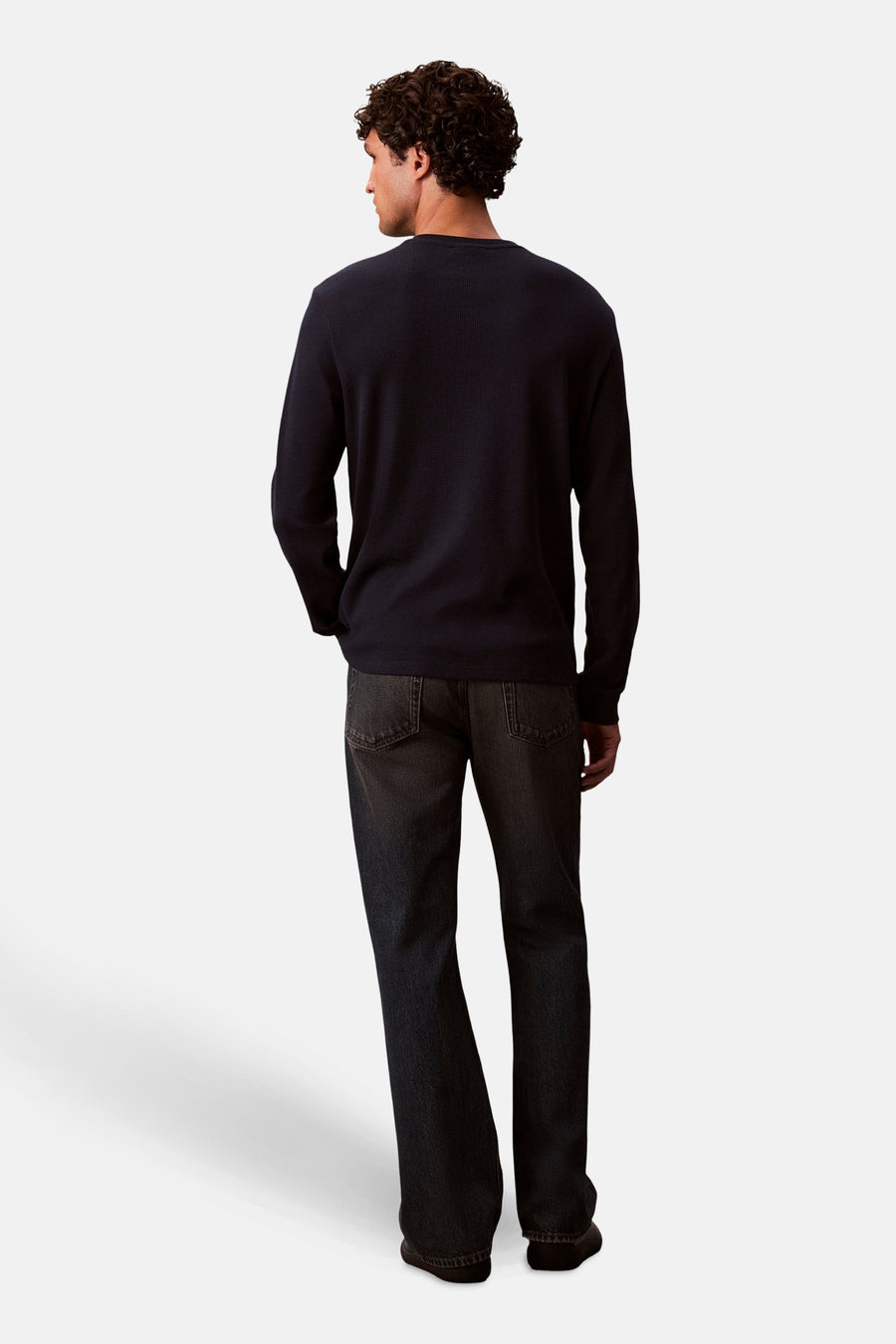 Blauwe T-shirt met lange mouwen van Calvin Klein, gedragen met een donkere spijkerbroek, achtergezicht.