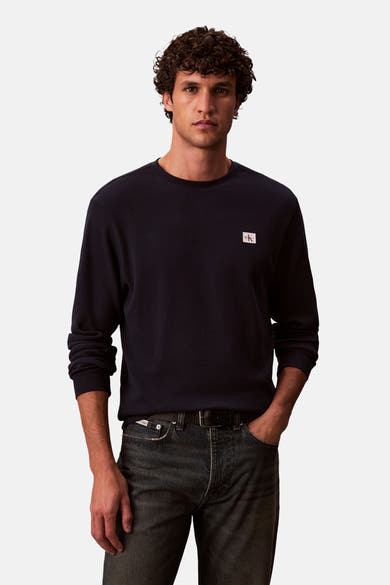 Blauwe T-shirt met lange mouwen van Calvin Klein, wafelpatroon, gedragen met een donkere spijkerbroek en een zwarte riem.
