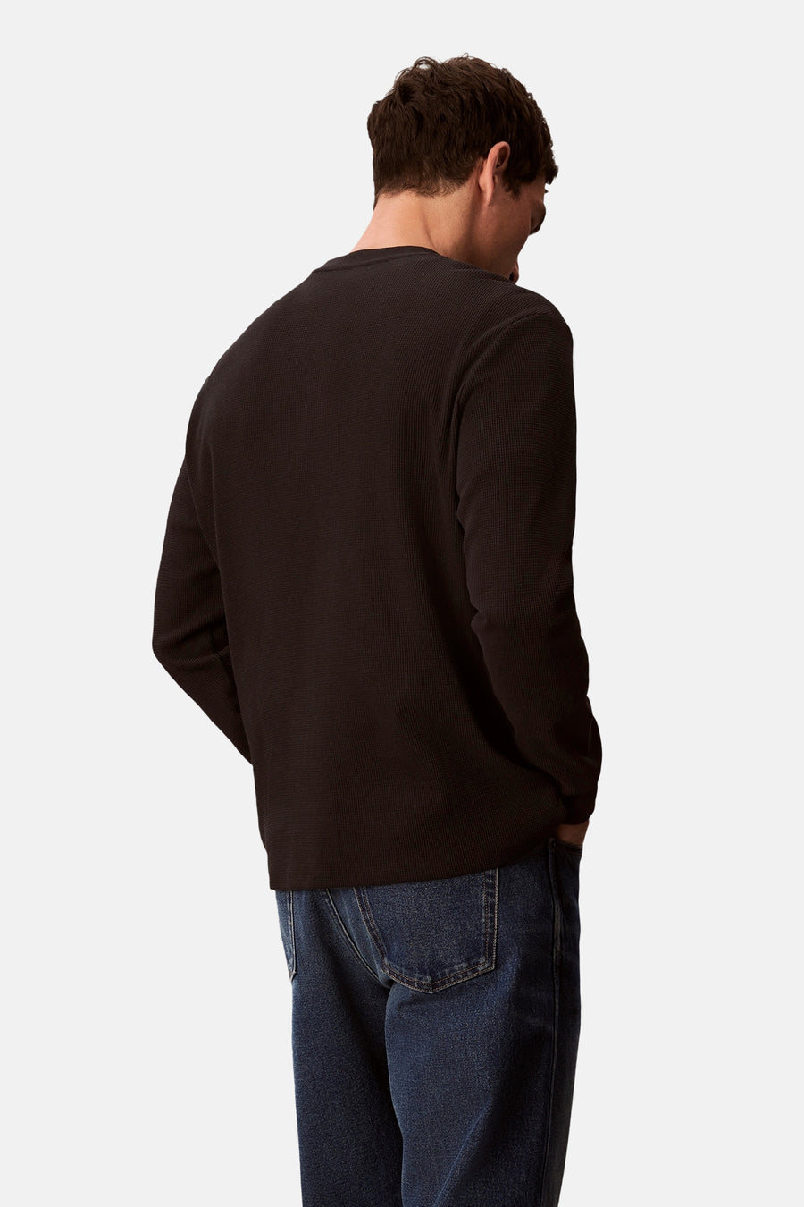 Zwart T-shirt met lange mouwen van Calvin Klein, van achteren gezien, gedragen met een spijkerbroek.