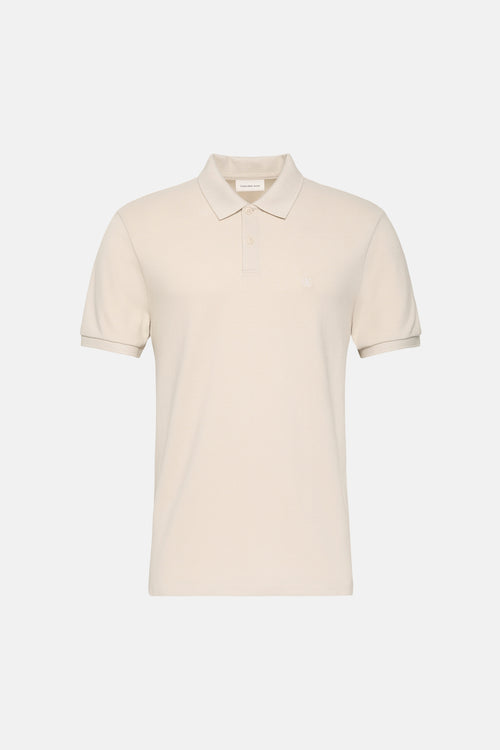 Polo à manches courtes écru de Calvin Klein Jeans, avec patte de boutonnage et logo sur la poitrine.