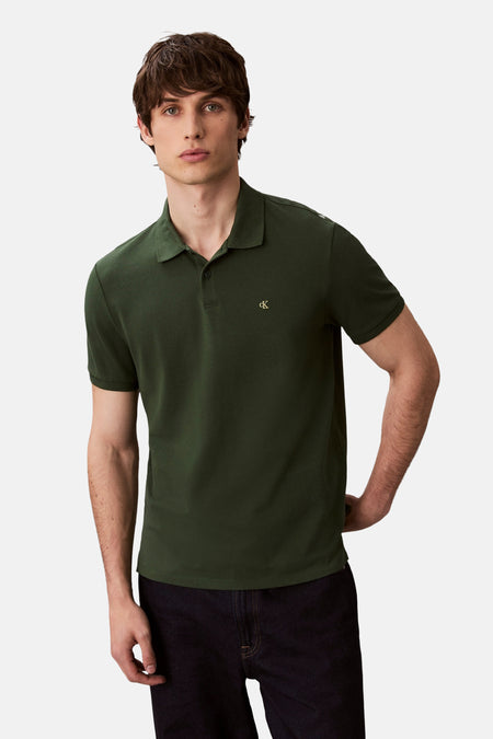 Groen poloshirt met korte mouwen van Calvin Klein, met toon-op-toon geborduurd logo, gedragen met een zwarte broek.