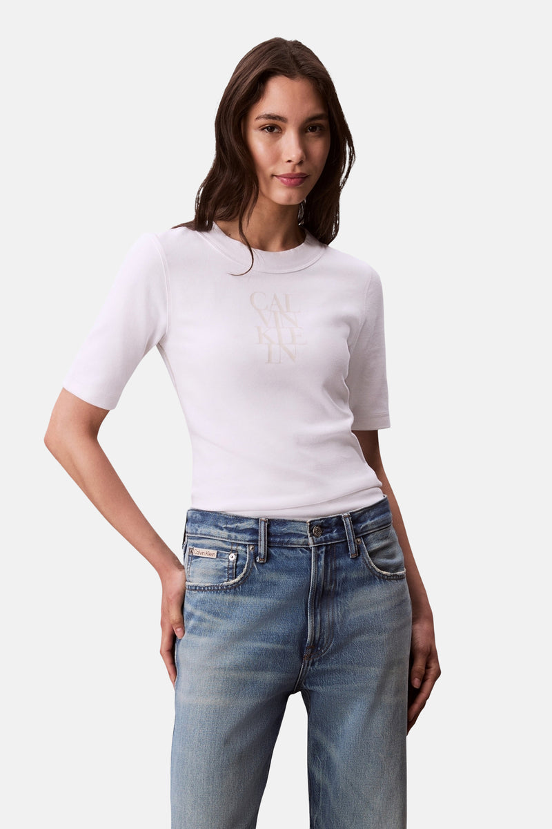 T-shirt blanc à manches courtes de Calvin Klein, porté avec un jean taille haute délavé.
