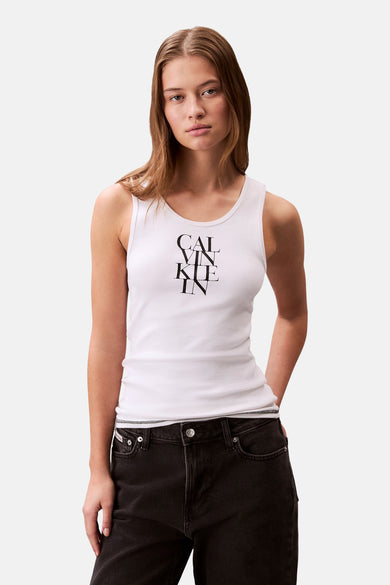 Wit Calvin Klein T-shirt zonder mouwen, gedragen met een wijde zwarte jeans en zwarte platte schoenen, met een handtas.