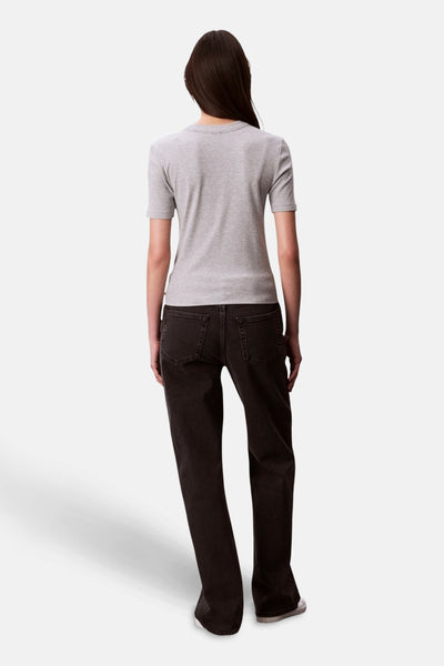 T-shirt gris à manches courtes de Calvin Klein, porté avec un jean noir taille haute.