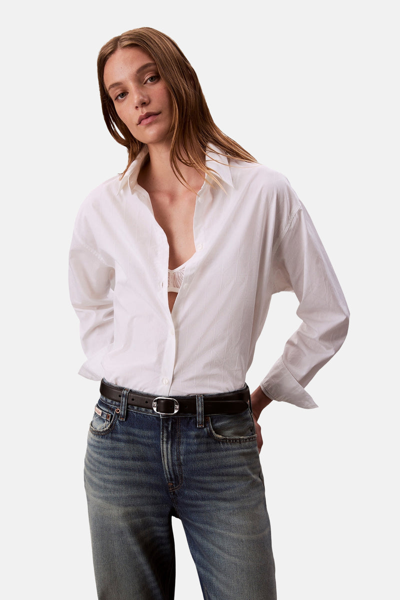 Wit Calvin Klein overhemd met lange mouwen, in toon-op-toon patroon, gedragen met witte kanten lingerie.