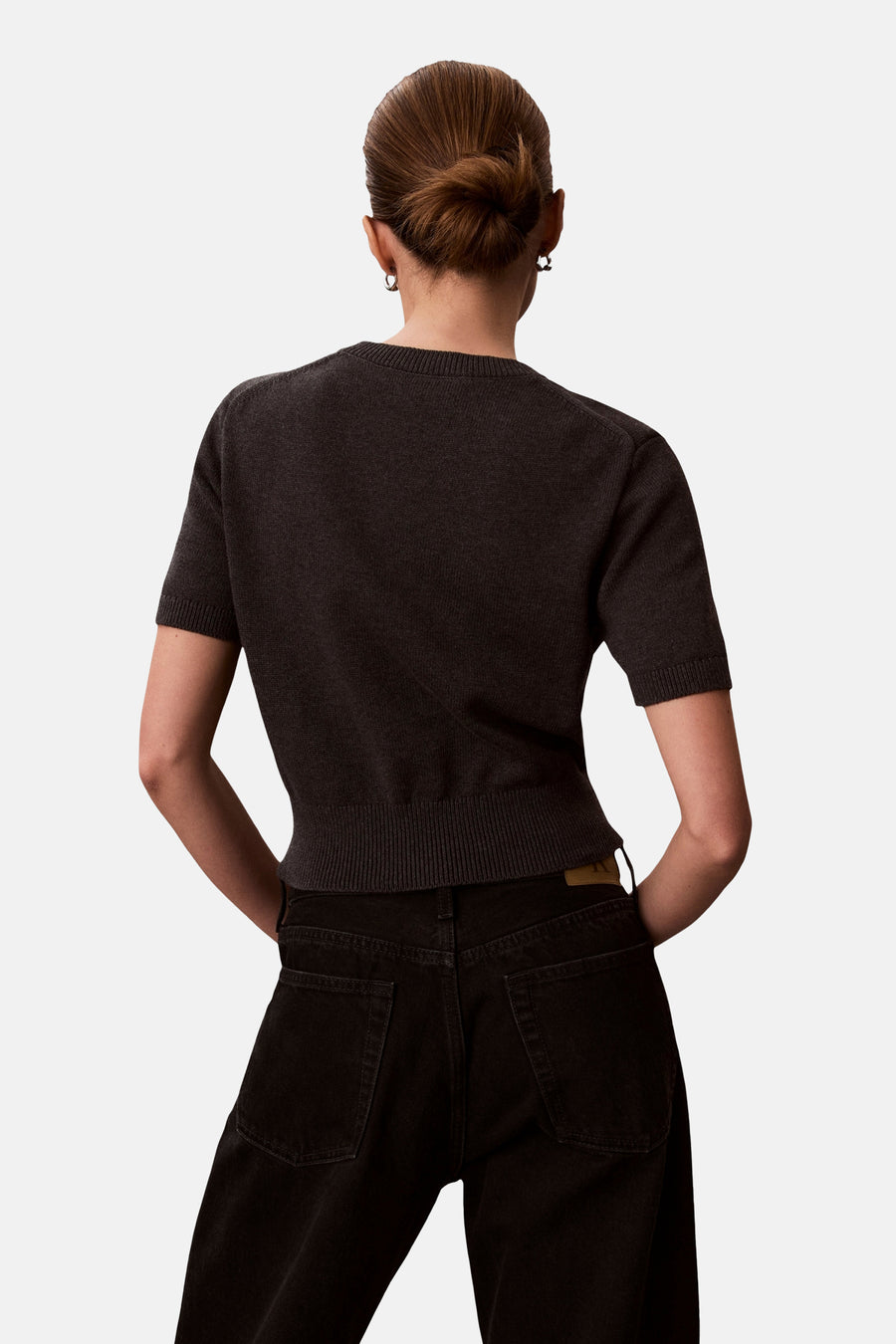 Pull à col rond gris de Calvin Klein, vu de dos, porté avec un jean noir.