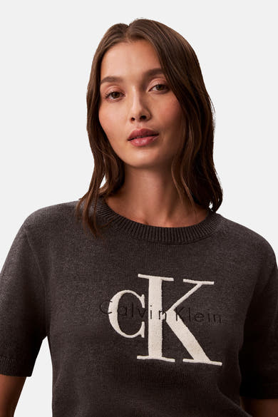 Pull à col rond gris de Calvin Klein, avec le logo "CK" en relief sur le devant.