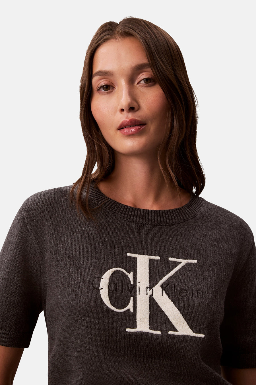 Pull à col rond gris de Calvin Klein, avec le logo "CK" en relief sur le devant.