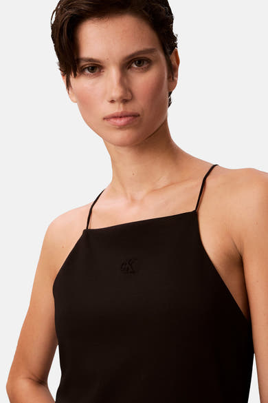 Robe noire de Calvin Klein avec fines bretelles et logo discret sur le devant.
