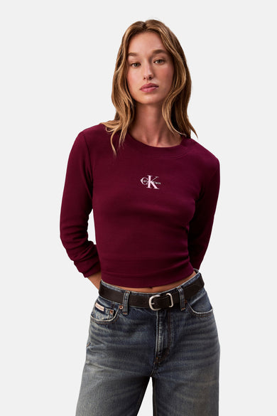 Bordeaux T-shirt met lange mouwen van Calvin Klein, gedragen met een high-waisted jeans en een zwarte riem.