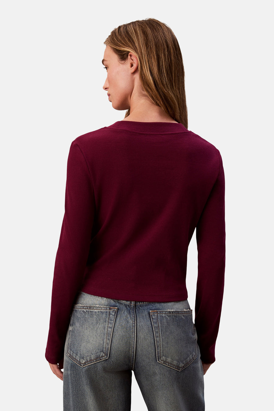 Bordeaux T-shirt met lange mouwen van Calvin Klein, in ribgebreide stof, gedragen met een low-rise jeans.