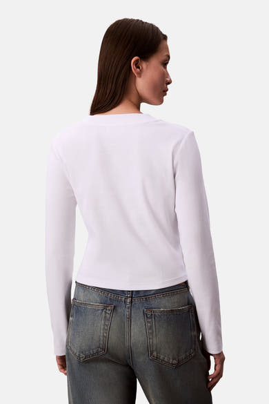 Wit T-shirt met lange mouwen van Calvin Klein, gedragen met een high-waisted lichtblauwe jeans, achtergezicht.