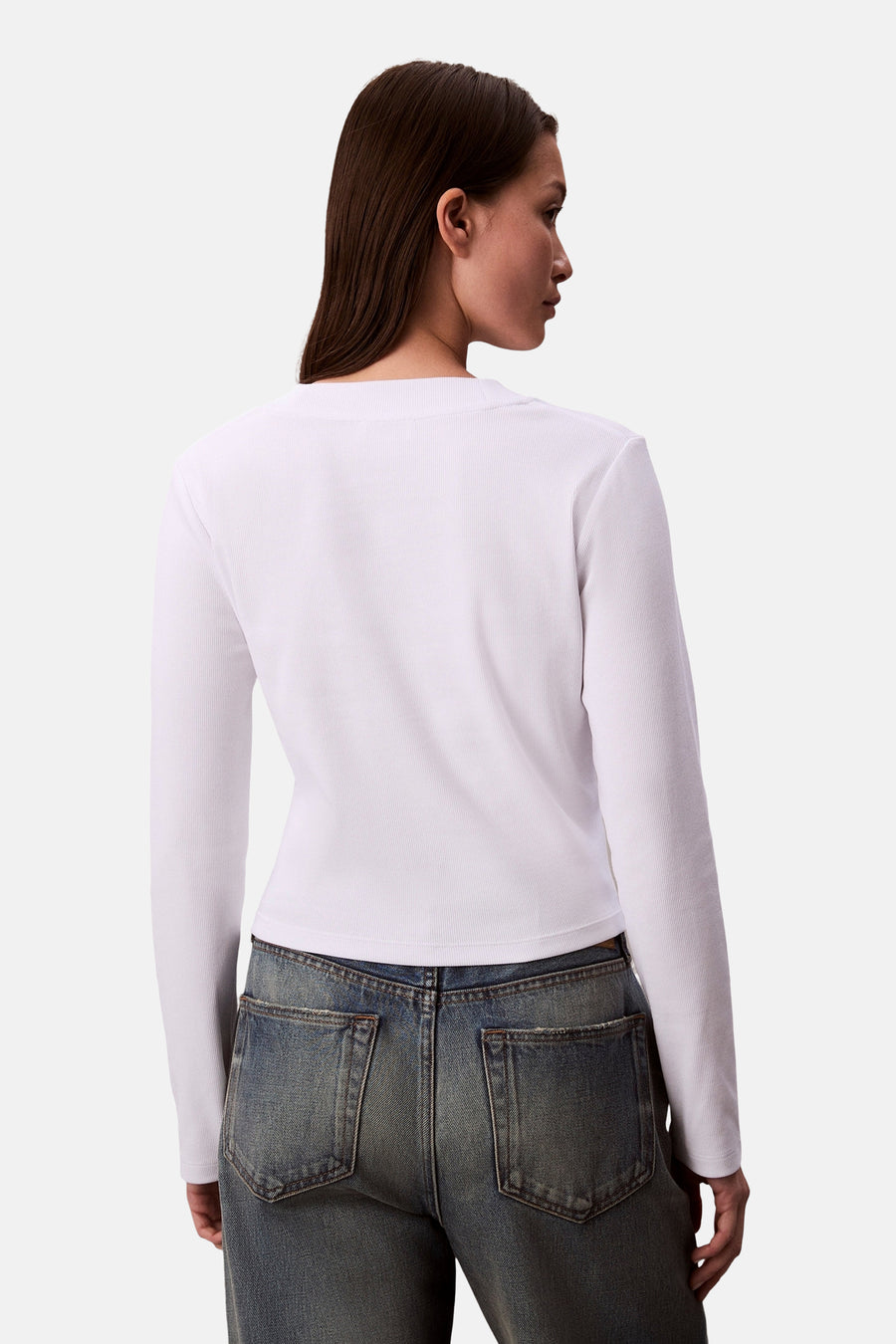 Wit T-shirt met lange mouwen van Calvin Klein, gedragen met een high-waisted lichtblauwe jeans, achtergezicht.