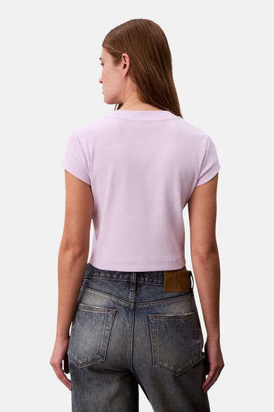 Paars T-shirt met korte mouwen van Calvin Klein, geribbelde textuur, gedragen met een high-waisted, lichtgewassen spijkerbroek.