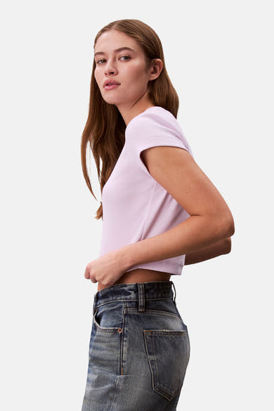 Paars T-shirt met korte mouwen van Calvin Klein, geribbeld, gedragen met een hoge blauwe spijkerbroek.
