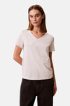 Beige T-shirt met korte mouwen van Calvin Klein, gedragen met een zwarte high-waist jeans.