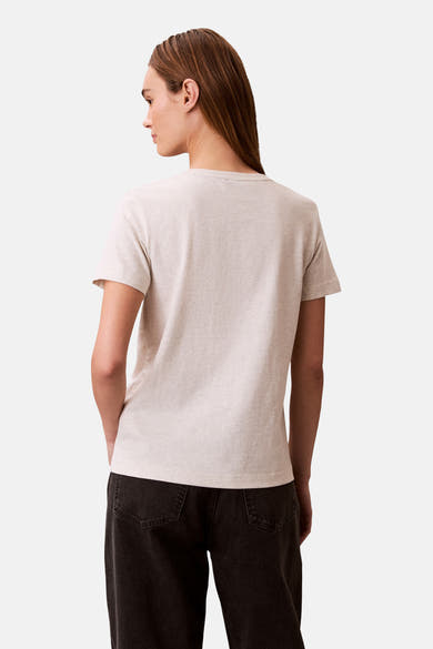 Beige T-shirt met korte mouwen van Calvin Klein, van achteren gezien, gedragen met een donkere broek.