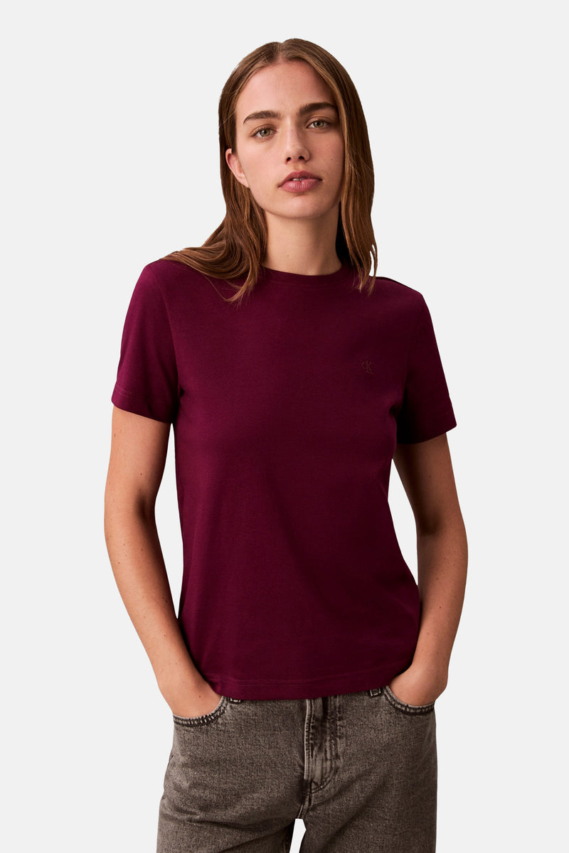 T-shirt rouge à manches courtes de Calvin Klein, porté avec un jean gris délavé.