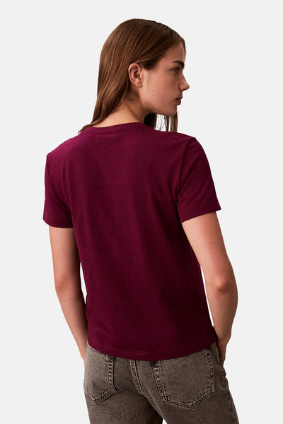 T-shirt rouge à manches courtes de Calvin Klein, porté avec un jean gris, vue de dos.
